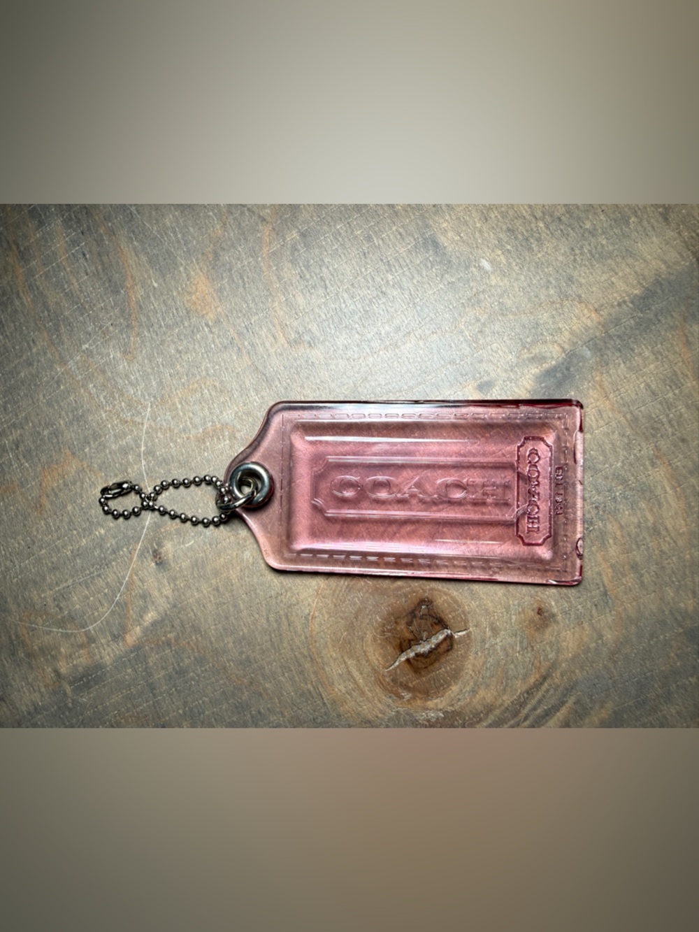 Coach pink translucent plastic or acrylic Coach Poppy hangtag bag charm.